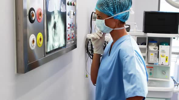 Female surgeon reading x-ray