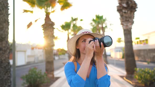 Photographer Tourist Woman Taking Photos with Camera in a Beautiful Tropical Landscape at Sunset