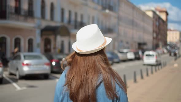 Happy Woman in Hat Walking Through the City Back View Woman Walking Down the Street and Smiling