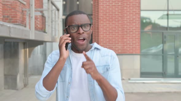 African Man Getting Angry on Call While Walking in Street