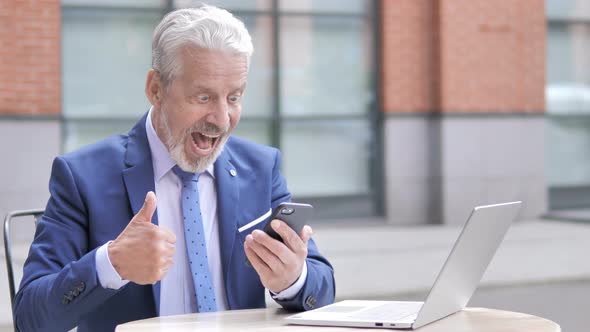 Old Businessman Excited for Success on Phone