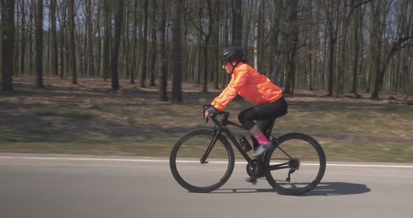 Woman cycling. Girl intensively cycling on road bike. Female pedalling on bicycle. Triathlon concept