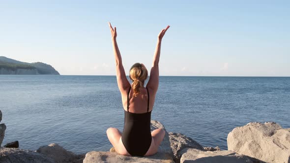 Happy Young Woman Arms Outstretched on the Beach at Sunrise