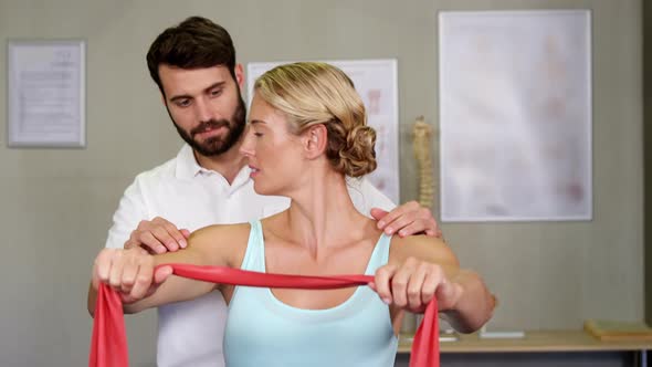 Male physiotherapist giving shoulder massage to female patient