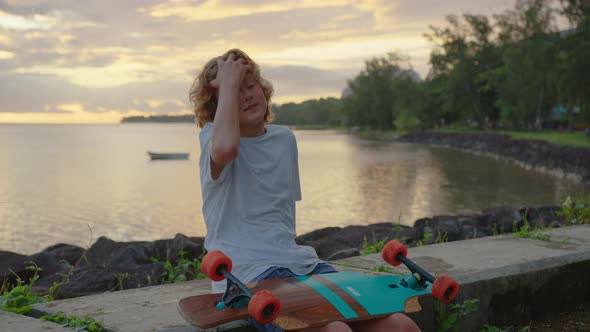 Silhouette Happy Child Portrait of Young Stylish Skater Boy Holding His Skateboard Outdoors