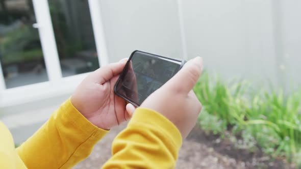 Happy african american plus size woman, using smartphone in garden