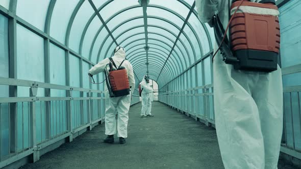 Professional Disinfectors Clean Overpass with a Sprayer.