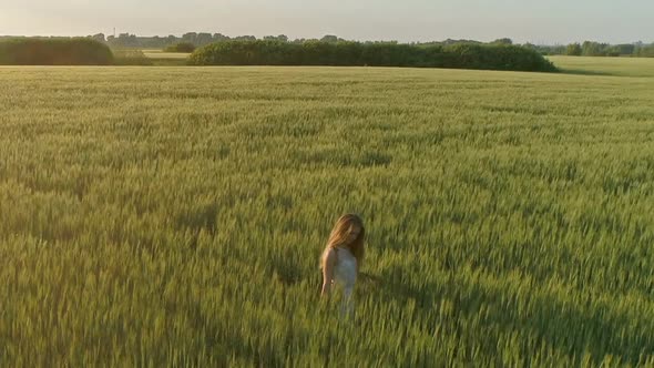 Beautiful Girl Walking in Wheat Field