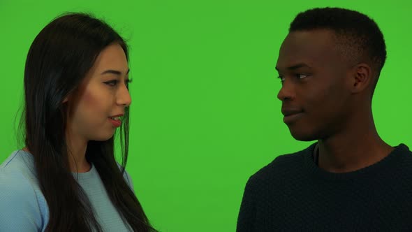 A Young Asian Woman and a Young Black Man Talk - Closeup on the Faces - Green Screen Studio