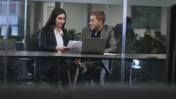 Young Lustful Man Boss Harassing His Female Colleague Caressing Her Knee Under Table at Office