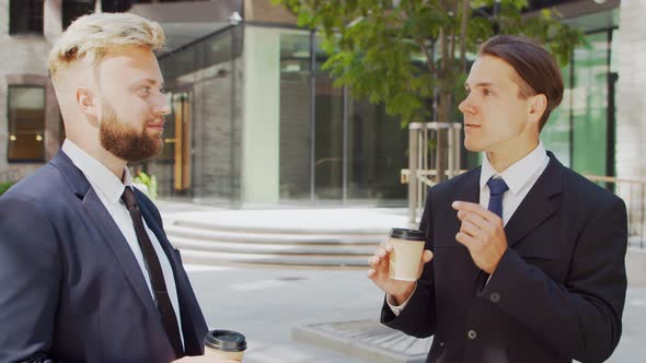 Confident businessman and his colleague in front of modern office building.