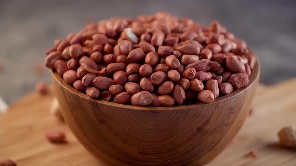 Raw Peanuts in small wooden bowl on natural gray rustic desk Video 4k