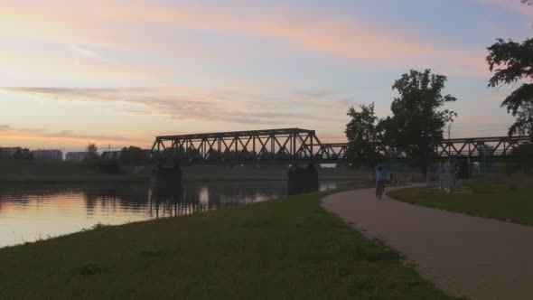 Evening Bridge over the River Cyclist Rides Along