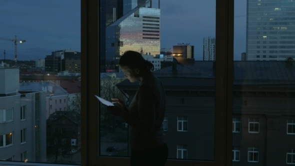 Woman Typing In Tablet By The Window