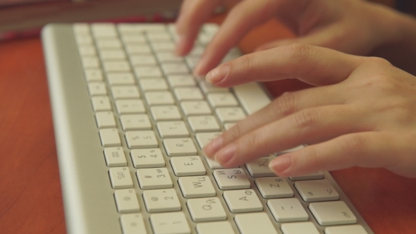 Female Hands Typing On a White Keyboard.