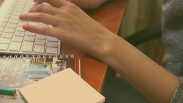 Female Hands Typing On a White Keyboard