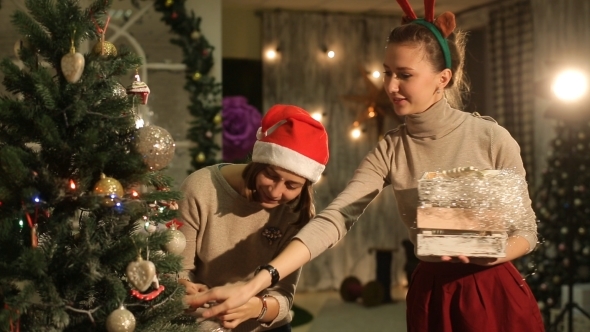 Two Friends Decorate a Christmas Tree