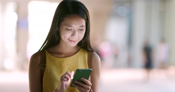 Woman use of mobile phone in the city at night