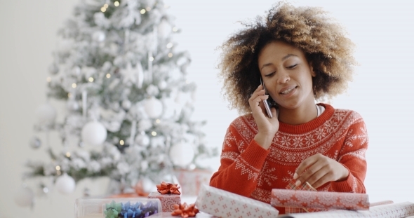 Young African Woman Wrapping Gifts At Christmas