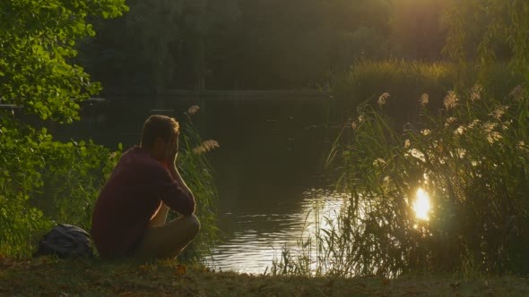 Man is Sitting at Lake Bank Man's Silhouette Man