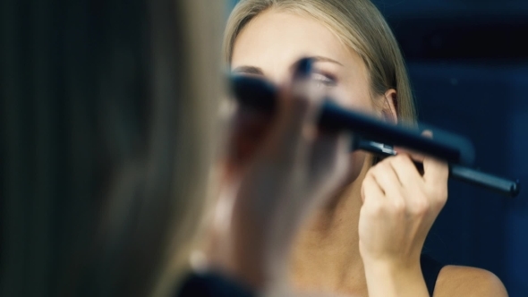 Attractive Girl Doing Makeup In a Mirror