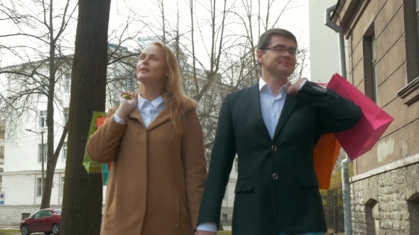 Elegant Man And Woman Walking After Shopping