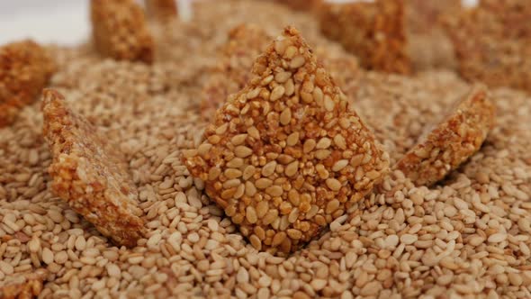 Rotating view of sesame seeds stick placed over heap of sesame seeds