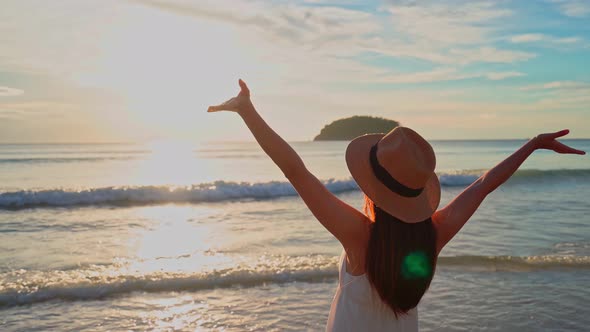 Young woman traveler walking and enjoying beautiful Sunset on the tranquil beach