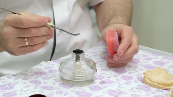 Dental Technician Heats the Instrument for Fabricating Removable Dentures