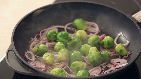 Brussel Sprouts With Onions Frying On a Pan