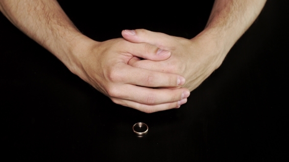 Mans Hands Takes Off a Ring Put On Black Table