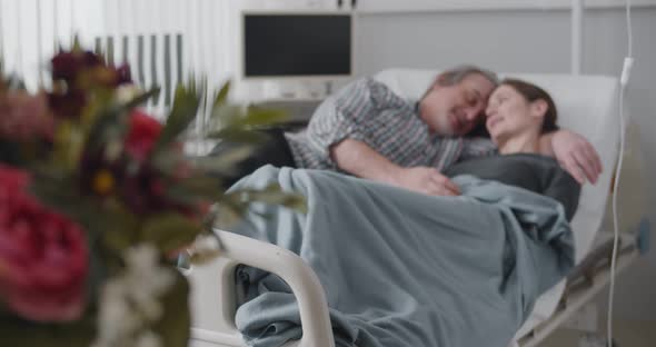 Mature Man Visiting Sick Wife in Hospital and Bringing Flowers