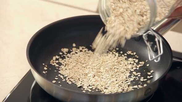 Chef Is Drying Oat-Flakes On a Frying Pan