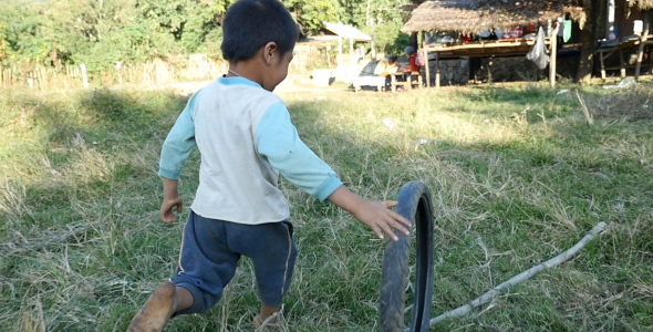Poor Litle Boy Playing With A Used Bike Tire
