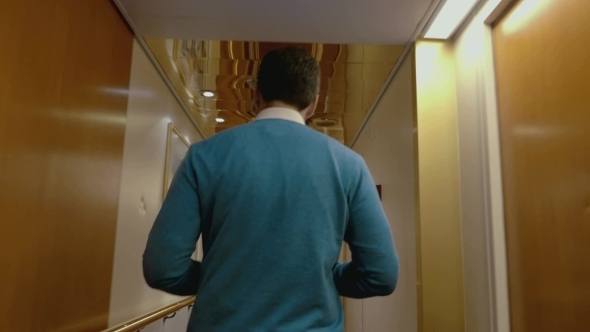 Man Walking Along The Hotel Corridor