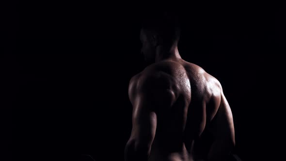 Fit and sporty bodybuilder over black background.