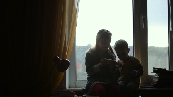 Children Sitting On The Windowsill