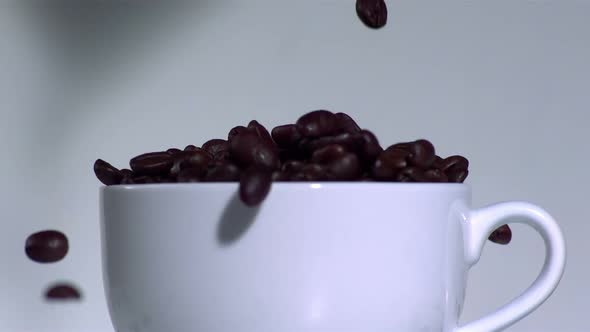 Overflowing coffee beans in a white cup