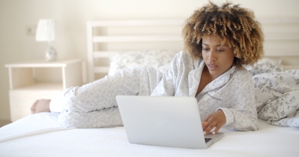 Cute Woman Using Laptop On Bed.