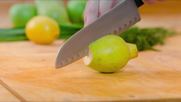 Knife Cutting Pear On Wooden Cutting Board