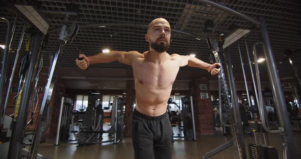 A Young Athlete Trains the Muscles of the Chest and Back with a Heavy Weight