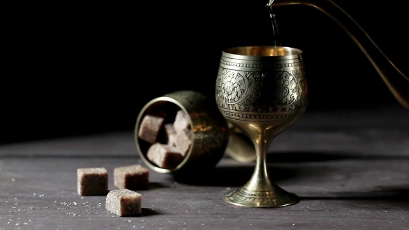 Tea Pouring Into Glass From Metal Teapot