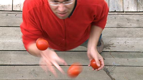Man Juggling With Tomatoes
