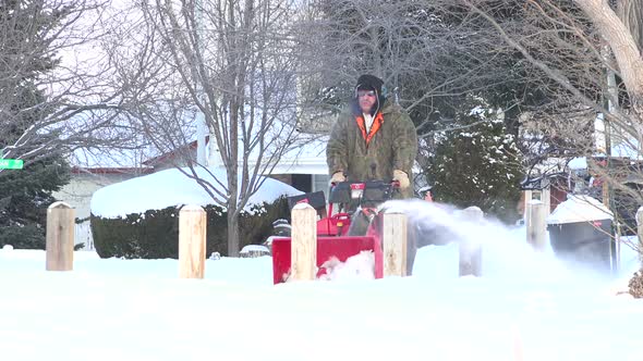 Man Snowblowing The Sidewalk