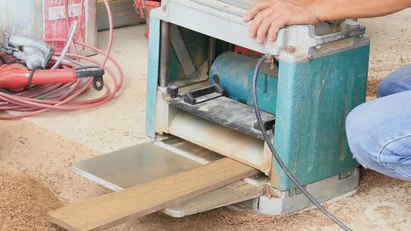 Carpenter Putting Board Through A Planer 2