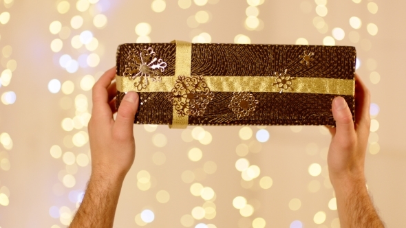 Brown Gift Box With Golden Ribbon And Snowflakes