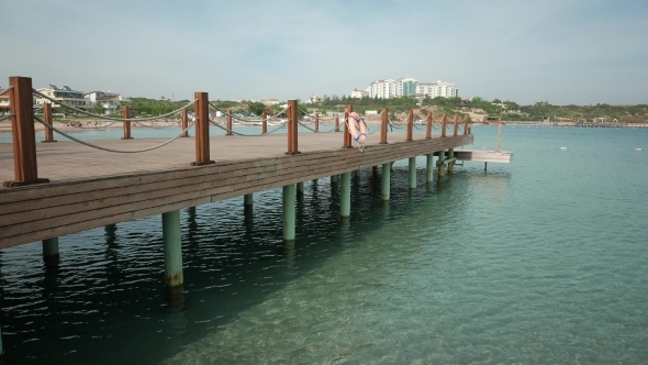 Emty Wooden Bathing Pier With Lifelines With Beach