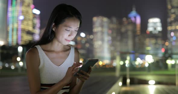 Woman working on cellphone at night 