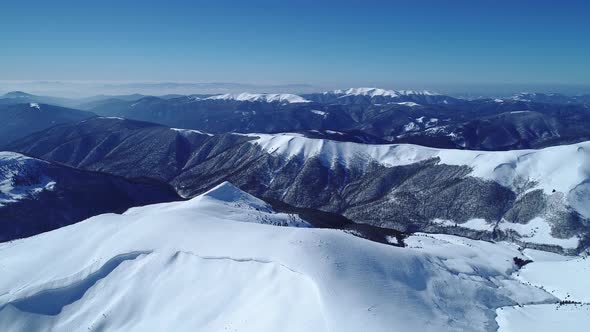 Flight over the turquoise snowy mountains illuminated by the day sun