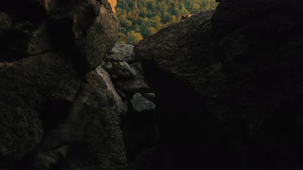 Motion Along Rocky Wall To Hole Opening View on Green Hills